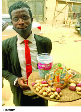 Meet The 24-Year-Old Man Who Wears Suit To Hawk Kolanuts In Abuja Traffic (Photo)