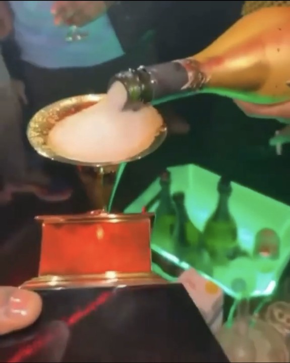 Burna Boy Drinks Champagne With His Grammy Award